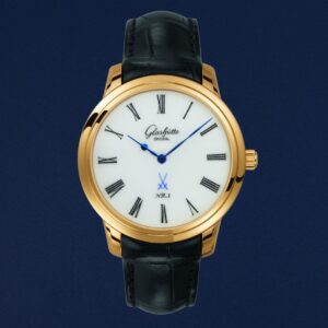 Orologio Glashütte Original Senator Meissen NR.1 con quadrante in autentica porcellana bianca Meissen, logo spade incrociate blu, cassa in oro giallo e cinturino in pelle nera, su sfondo blu profondo.