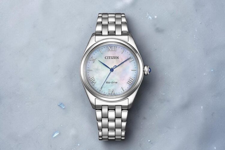 Citizen Arcly Eco-Drive Citizen Arcly Eco-Drive con quadrante madreperla e bracciale in acciaio su sfondo ghiacciato.
