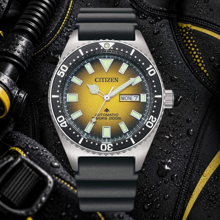 Citizen Promaster NY0120-01X Diver’s 200 m Citizen Promaster NY0120-01X Diver’s 200 m con quadrante giallo e cinturino nero su sfondo di muta subacquea bagnata.
