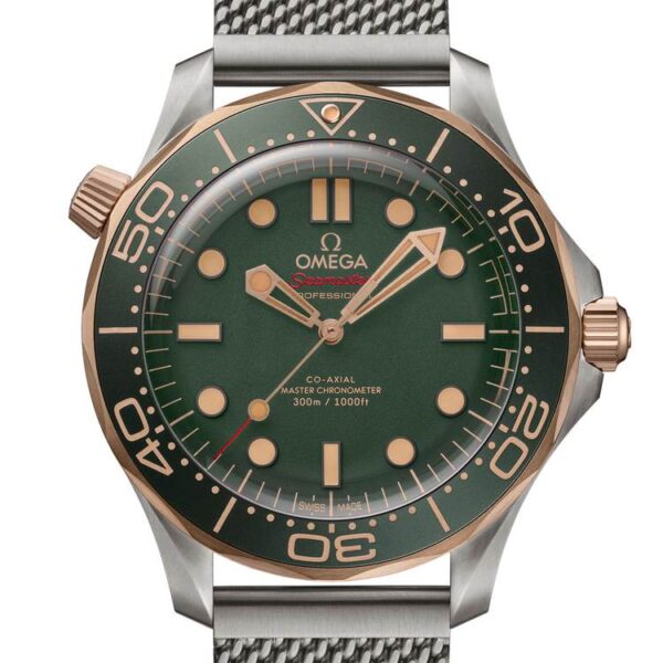 Primo piano del quadrante dell'Omega Seamaster Diver 300M con cassa in titanio e lunetta in Bronze Gold. Il quadrante verde è caratterizzato da indici e lancette in oro rosa, circondata da una lunetta verde con scale diving. Il tutto montato su un bracciale mesh in titanio