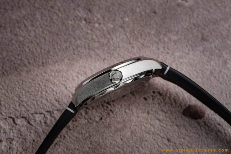 Dettaglio cassa Omega Railmaster 2025: vista di tre quarti con finiture lucide e spazzolate a contrasto e corona con logo Ω.