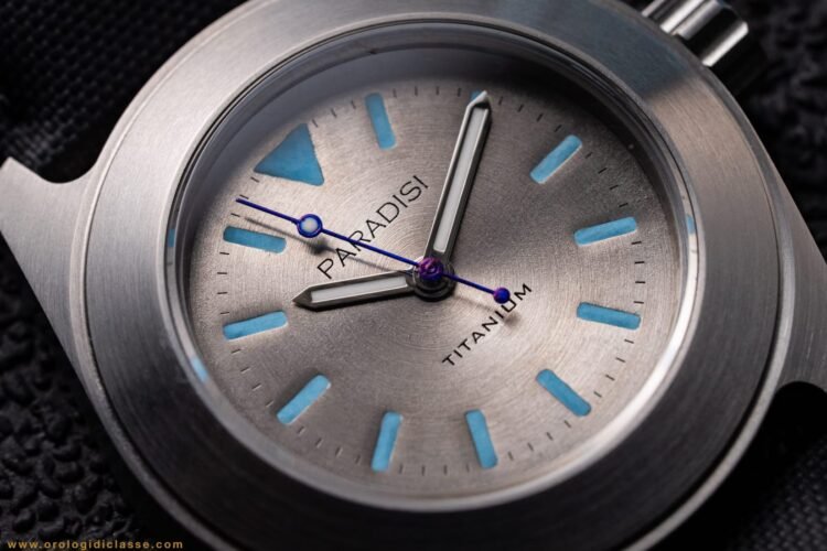 Zoom sul quadrante in titanio del Paradisi RP 02 Custom Series: dettagli della finitura satinata, indici e sfere con Super-Luminova blu.