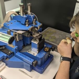 Un'artigiana al lavoro nella nuova manifattura di quadranti Glashütte Original. Equipaggiata con una lente da orologiaio, esegue una lavorazione manuale di altissima precisione su un quadrante per orologi di lusso.