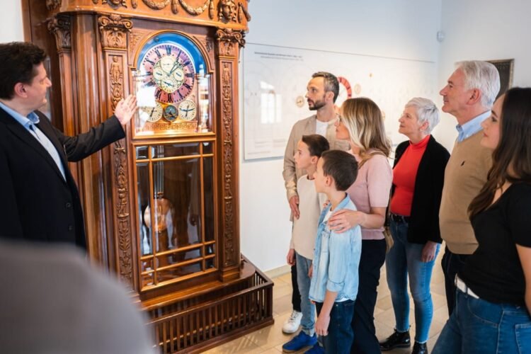Visitatori ammirano orologio astronomico Hermann Goertz dopo 100 anni di funzionamento nel Museo Glashütte.
