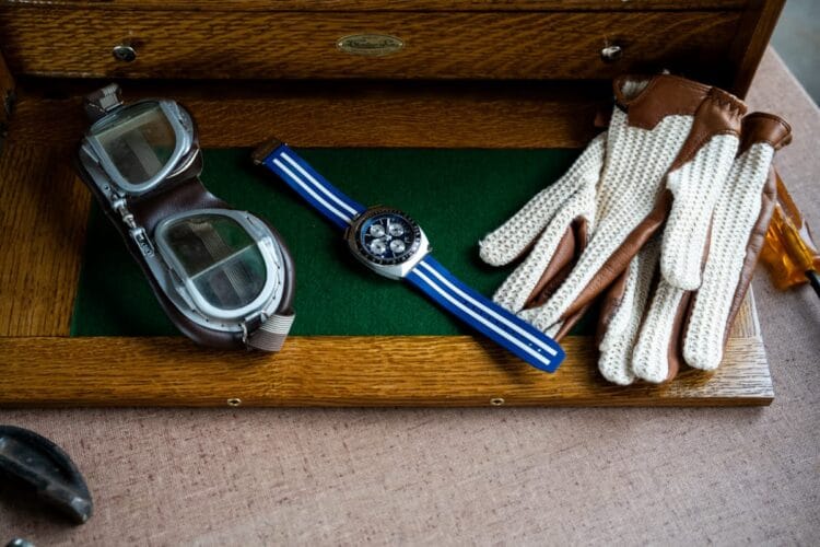 Bulova Shelby 150th (98B452) – passione orologi e motori Bulova Shelby 150th Racer Chronograph (98B452) su vassoio con occhiali e guanti da guida: passione orologi e motori