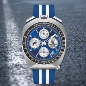 Bulova Shelby Racer Chronograph 150th (98B452) bullhead, quadrante blu e cinturino a strisce, su sfondo asfalto bagnato