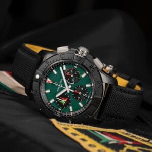 Cronografo da pilota Breitling Avenger con quadrante verde e cassa nera su cinturino tecnico, su sfondo giacca da volo
