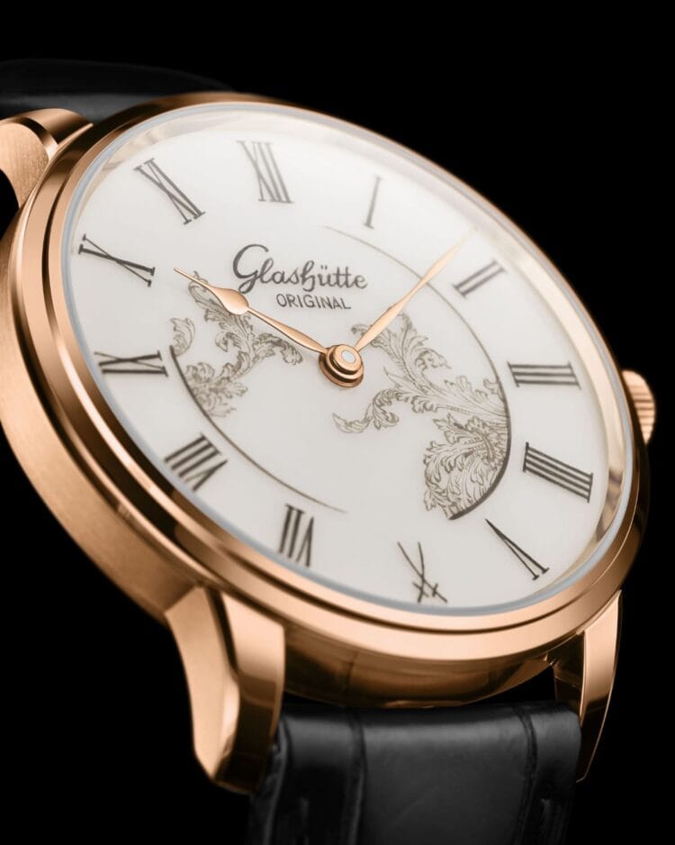 Dettaglio del quadrante in porcellana Meissen del Glashütte Original Senator Meissen Mystic Maison bianco: decorazione dipinta a mano, cifre romane e lancette curve in oro rosso Dettaglio del quadrante in porcellana Meissen del Glashütte Original Senator Meissen Mystic Maison bianco: decorazione dipinta a mano, cifre romane e lancette curve in oro rosso