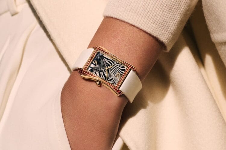 L'eleganza del Gondolo Serata Zebra Patek Philippe indossato. Il Patek Philippe Gondolo Serata Zebra al polso di una donna con un maglione color crema, che ne mostra la portabilità e il cinturino bianco.