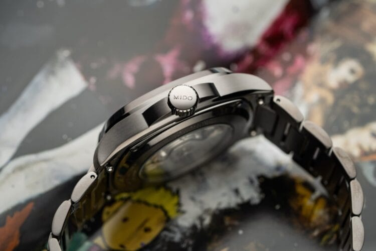 Profilo della cassa e corona del Mido S01E02 Profilo laterale della cassa del Mido Multifort TV S01E02, che evidenzia la finitura PVD grigio satinato, la corona firmata MIDO e l'integrazione del bracciale.