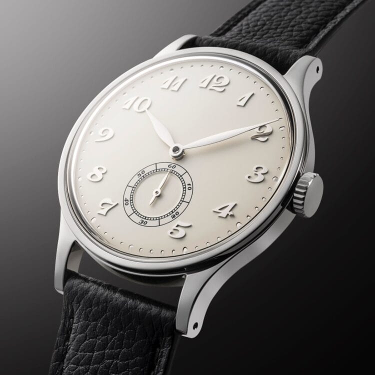HU-01 Vintage White: dettaglio della cassa in acciaio lucido a specchio da 36mm con vetro zaffiro bombato, corona zigrinata e quadrante crema con guilloché sul sottoquadrante dei secondi.