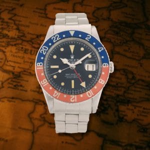 Orologio Rolex GMT-Master ref. 6542 con ghiera Pepsi rosso e blu su sfondo di mappa geografica vintage.