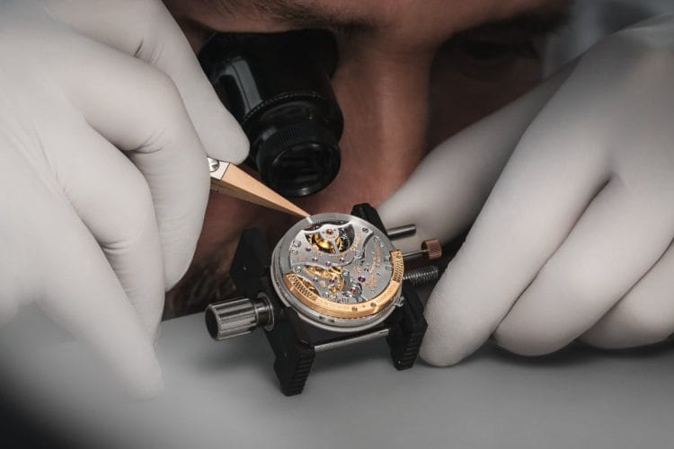 Maestro orologiaio Vacheron Constantin al lavoro su movimento con Punzone di Ginevra - Alta Orologeria artigianale Vacheron Constantin usati alta orologeria Holy Trinity movimento artigianale orologiaio al montaggio movimento