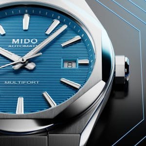 Dettaglio macro del quadrante blu intenso con lavorazione a linee orizzontali, indici applicati e datario del Mido Multifort 8 One Crown.
