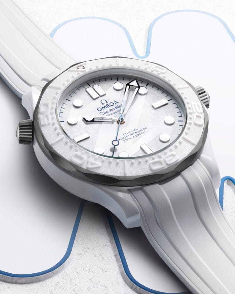 Dettaglio quadrante bianco effetto ghiacciato Omega Seamaster Milano Cortina 2026 con incisione laser motivo "26" e lancette scheletrate.
