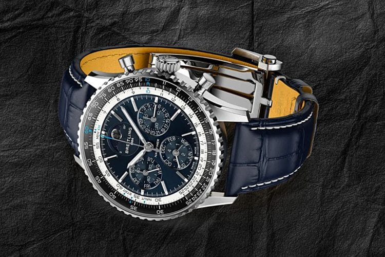 Breitling Navitimer B19 Chronograph 43 Perpetual Calendar – Cassa in Platino e Fibbia Deployante Breitling Navitimer B19 Chronograph 43 Perpetual Calendar in platino, vista tre quarti con cinturino in alligatore blu navy e fibbia deployante in oro bianco.