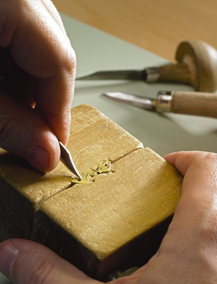 Incisioni floreali Glashütte Original: ogni ponte del bilanciere è un pezzo irripetibile Artigiano Glashütte Original incide a mano il ponte del bilanciere a farfalla con motivi floreali sul supporto ligneo rotante.