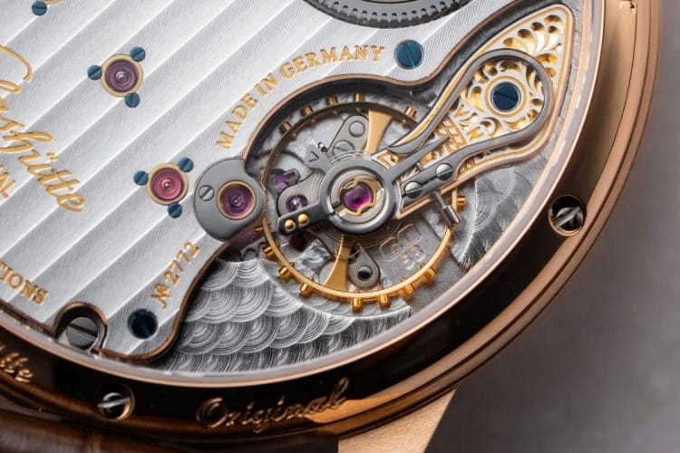 Movimento Glashütte Original 58-01: anglage, incisioni floreali e il sistema cromatico rosso-blu-oro Dettaglio del calibro 58-01 Glashütte Original con anglage sui ponti, incisioni floreali, viti azzurrate e castoni in oro.
