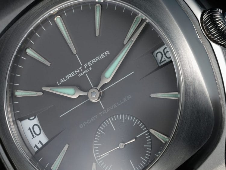 Laurent Ferrier Sport Traveller – Quadrante Slate Grey Opalino, Lancette Assegai e SuperLumiNova Primo piano frontale del quadrante slate grey opalino del Laurent Ferrier Sport Traveller: lancette assegai in oro bianco 18K con Super-LumiNova verde, scritta "Sport Traveller" tono su tono, ora di casa a ore 9, data semi-istantanea a ore 3 e piccoli secondi a ore 6.