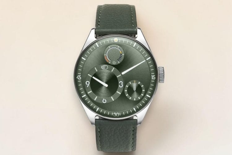 Ressence Type 11 Pine – Watches and Wonders 2026 Ressence Type 11 Pine presentato a Watches and Wonders 2026: orologio in titanio grado 5 da 41 mm con quadrante verde pine convesso, modulo ROCS 11.1 e indicazione dell’ora tramite dischi rotanti, cinturino verde abbinato.
