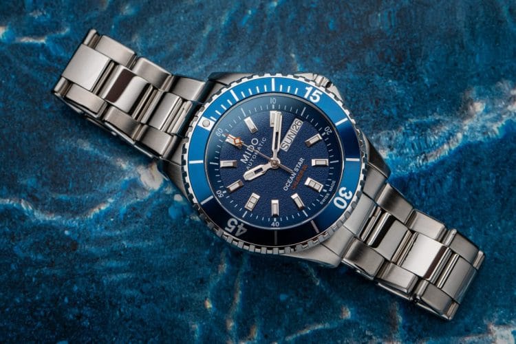Dettaglio ravvicinato del nuovo orologio Mido Ocean Star 200 da 41 mm. In evidenza il quadrante blu con finitura a grana fine, l'inserto della lunetta in alluminio e l'alternanza di finiture lucide e satinate sul bracciale in acciaio.