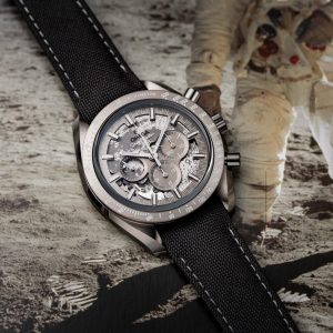 Omega Speedmaster Grey Side of the Moon in ceramica al plasma grigia su cinturino nylon, posato su stampa fotografica lunare con astronauta NASA sullo sfondo.