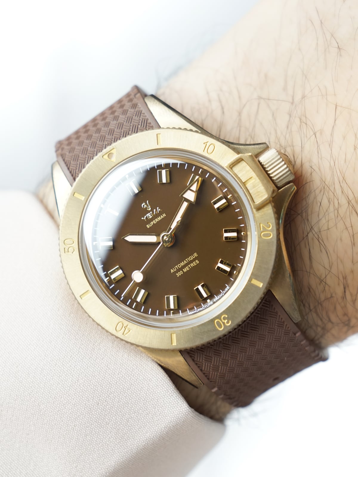 Yema Superman Bronze CMM.10 al polso: cassa da 39mm Yema Superman Bronze CMM.10 con quadrante marrone indossato al polso, cassa in bronzo da 39mm e dispositivo di blocco ghiera a ore 3