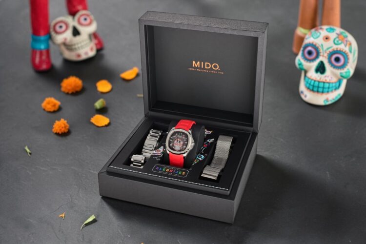Confezione Mido Multifort TV Alebrijes con cinturino e bracciali Mido Alebrijes con maglia milanese, accanto al bracciale in acciaio e al cinturino in caucciù rosso.