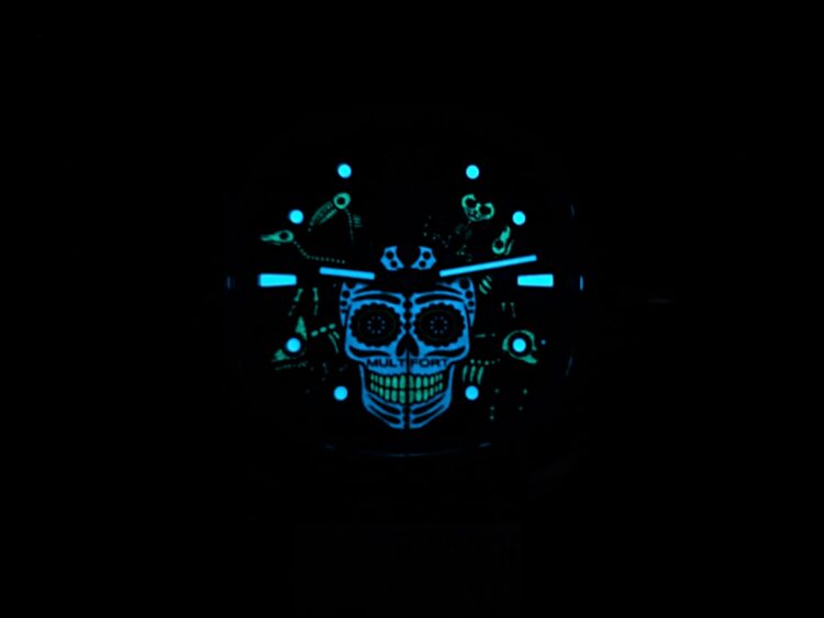 Mido Alebrijes: quadrante luminescente al buio Calavera del Mido Alebrijes illuminata al buio in blu e verde, con lancette e indici luminescenti.