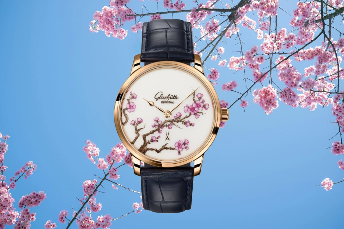 Glashütte Original Senator Meissen Cherry Blossom su sfondo di rami di ciliegio in fioritura.